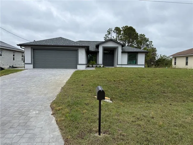 View of front of house with a garage and a front yard