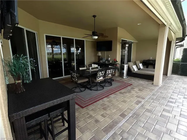 View of patio with ceiling fan and a grill