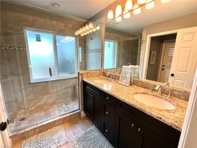 Bathroom with vanity and a shower with door