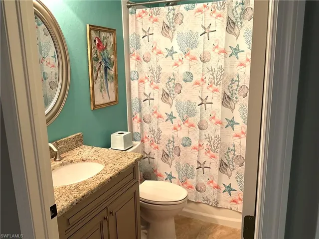 Full bathroom with tile patterned floors, vanity, toilet, and shower / tub combo