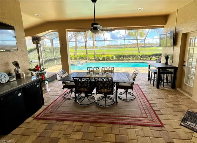 Patio featuring ceiling fan and vaulted ceilings, mini bar, 2 TV’s and panoramic views of water and golf course