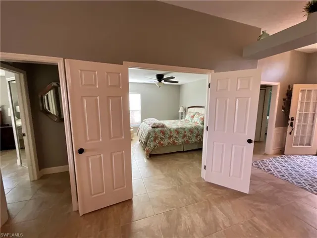 Tiled den/flex bedroom featuring ceiling fan and French doors