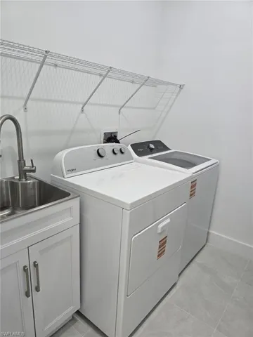Laundry room featuring a sink and separate washer and dryer