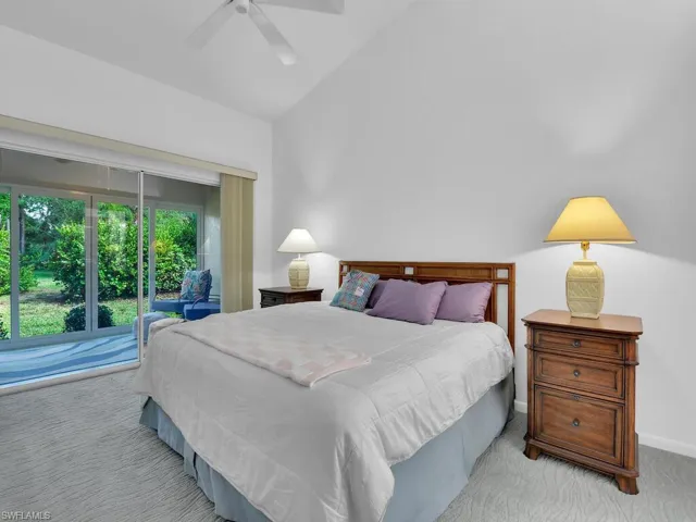 Carpeted bedroom with access to exterior, ceiling fan, and lofted ceiling