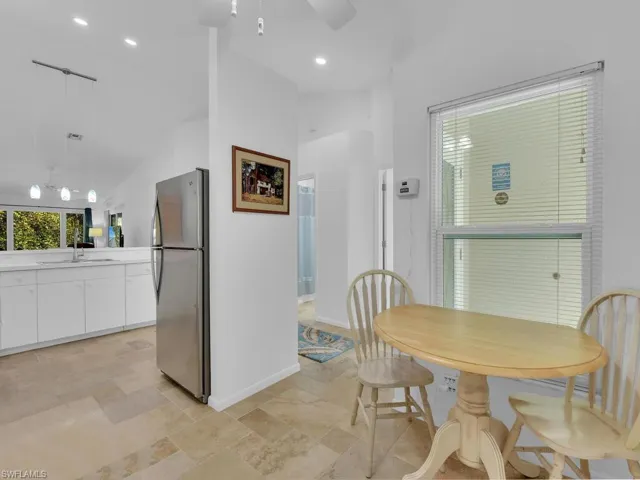 Dining space featuring ceiling fan, sink, and lofted ceiling