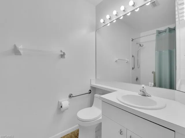 Full bathroom with vanity, shower / bath combination with curtain, and toilet