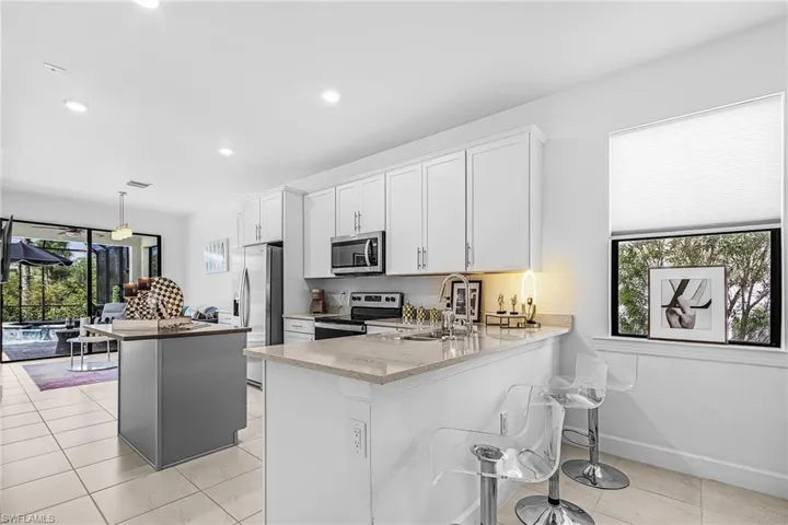 The kitchen and dining area flow seamlessly into the living space and extend to the outdoor living area.