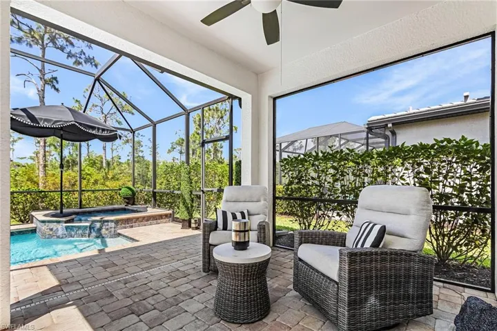 Outdoor living space features multiple seating areas for relaxing and entertaining