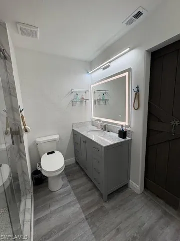 Bathroom featuring vanity, a shower stall, and light wood-style floors