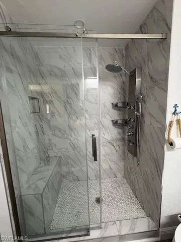 Full bathroom with a marble finish shower
