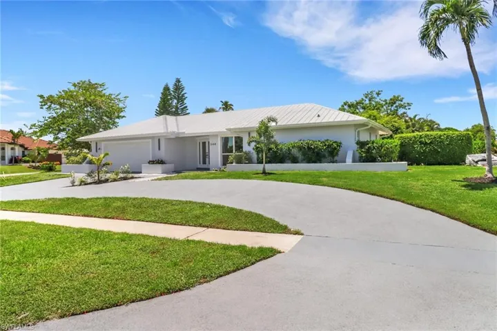 Ranch-style house with a garage and a front lawn