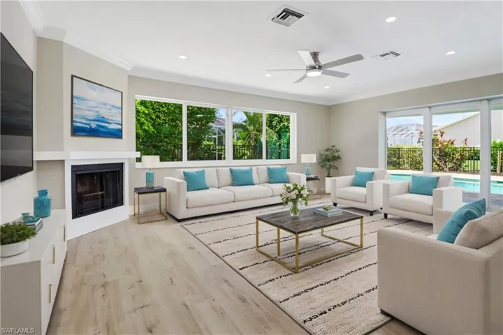 Living room featuring ceiling fan, crown molding, light hardwood / wood-style flooring, and a wealth of natural light
