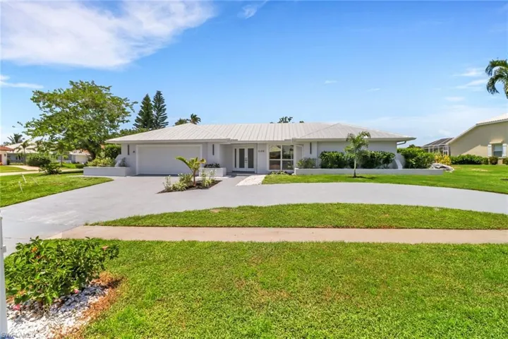 Single story home featuring a garage and a front yard