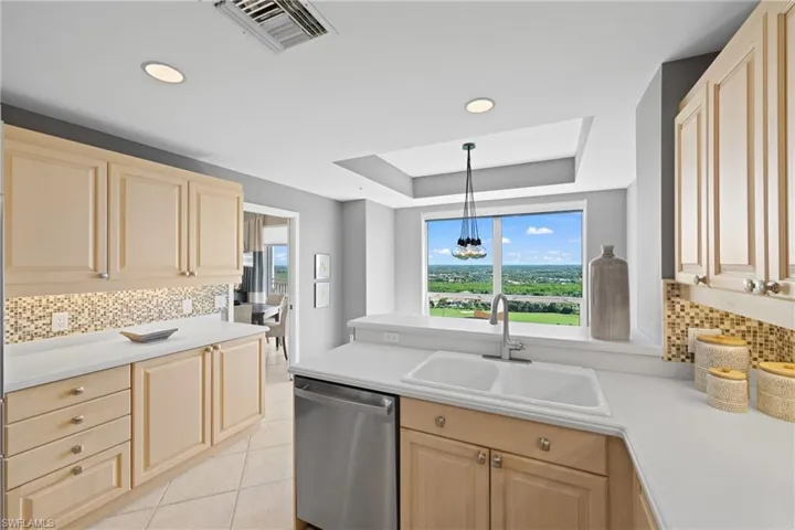 Kitchen with light wood cabinetry, recessed lighting, and a mosaic tile backsplash