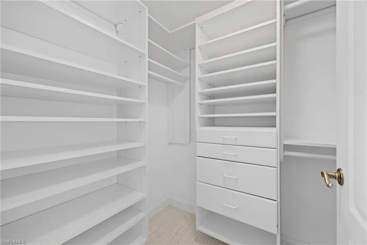 Custom closet organization system with extensive shelving, multiple drawers, and hanging rods