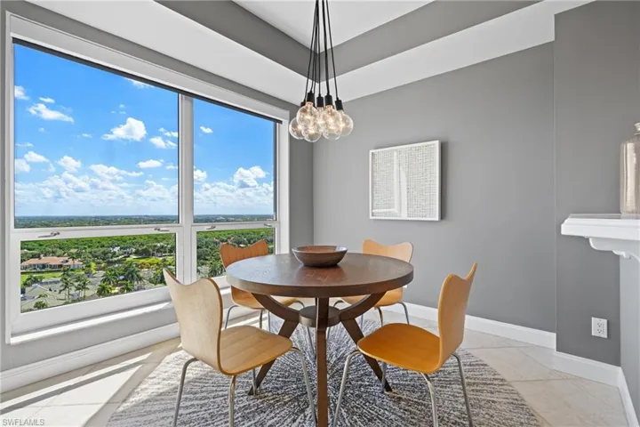 Expansive window offering a panoramic landscape, a modern pendant light fixture, and tile flooring