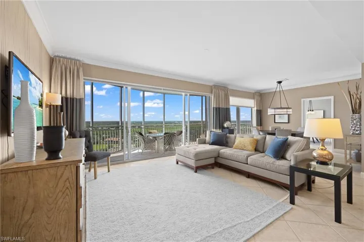 Expansive windows, tiled flooring, crown molding, and an outdoor balcony with metal railings