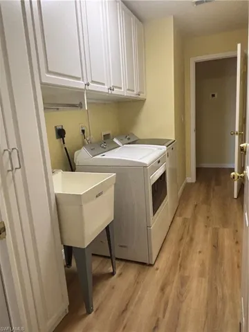 Laundry room with washing machine and dryer, sink, cabinets,