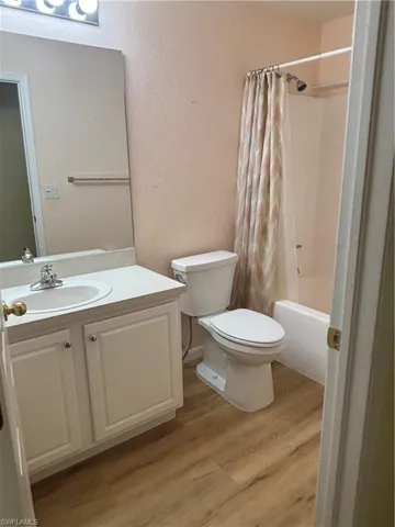 Guest bathroom with shower / bath combo with shower curtain, vanity, and toilet