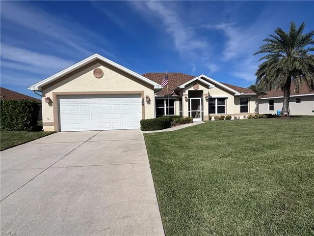 Single story home featuring a garage and a front yard