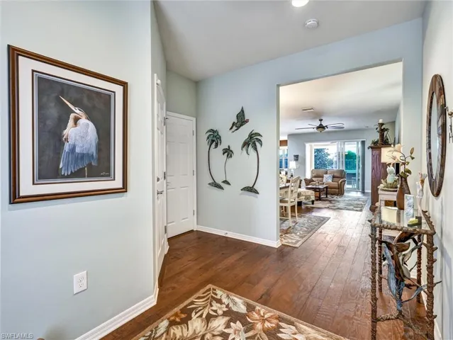 Hall with baseboards and dark wood-style flooring