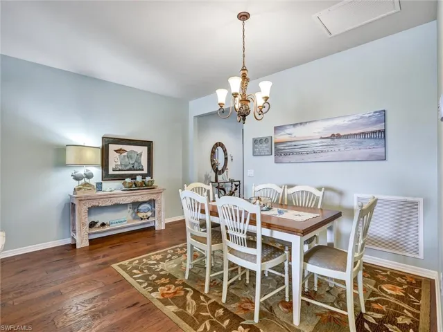 Dining room featuring suspended lighting and dark wood-type flooring