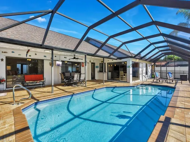 Outdoor pool featuring a lanai, a sunroom, a patio area, and outdoor dining space
