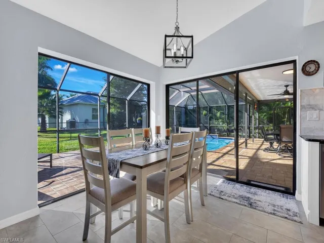 Sunroom featuring outdoor dining area, a patio area, lofted ceiling, and plenty of natural light