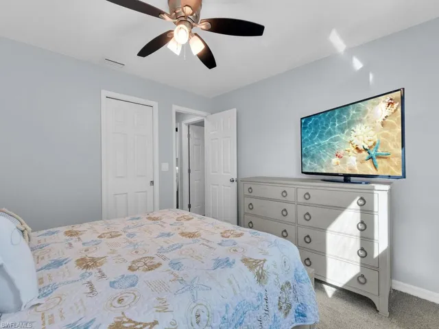 Carpeted bedroom featuring a ceiling fan