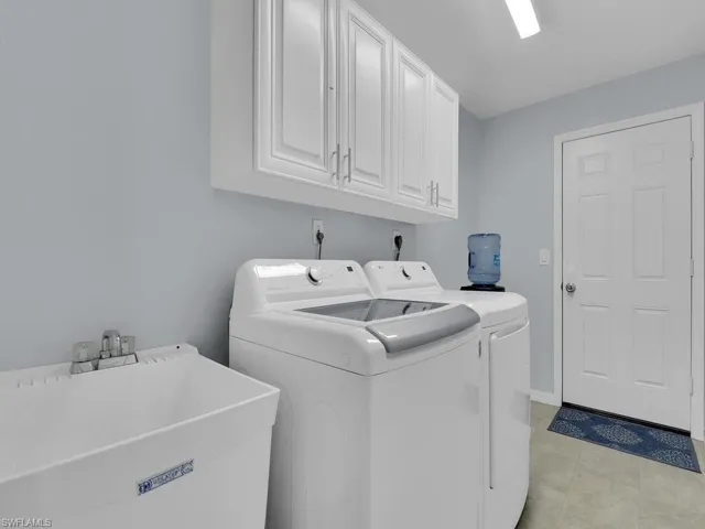 Laundry area with separate washer and dryer and cabinet space