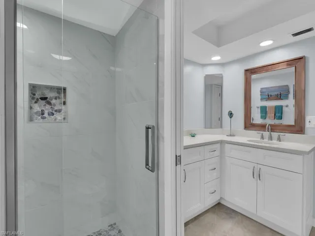 Full bathroom featuring vanity, a shower stall, recessed lighting, and light tile patterned floors