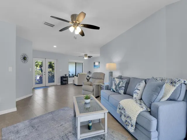 Living room featuring french doors, light tile patterned flooring, a ceiling fan, and recessed lighting