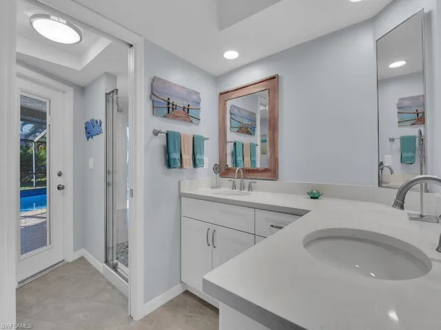 Full bath with a stall shower, double vanity, and recessed lighting
