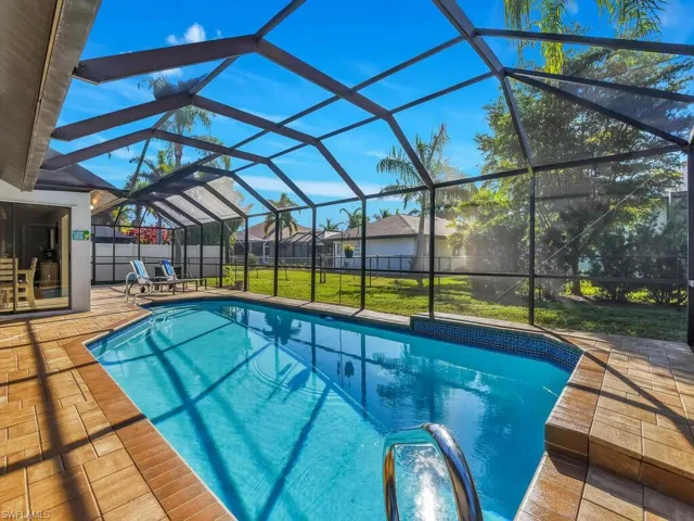 View of pool featuring a sunroom, glass enclosure, and a patio area