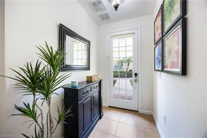 Doorway to outside with a textured wall and tile patterned floors