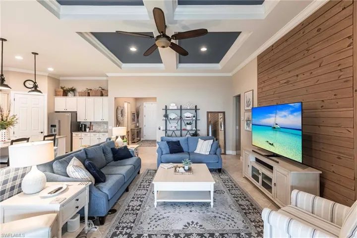 Living room with magnificent expansive lake views featuring coffered ceiling,  crown molding,  a neutral palette