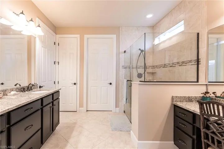 Primary bathroom features separate vanity, a shower stall, and separate toilet area.