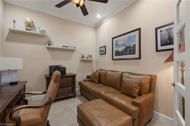 Tiled office space with crown molding and ceiling fan