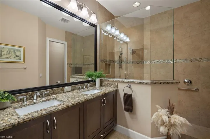Bathroom featuring vanity and tiled shower