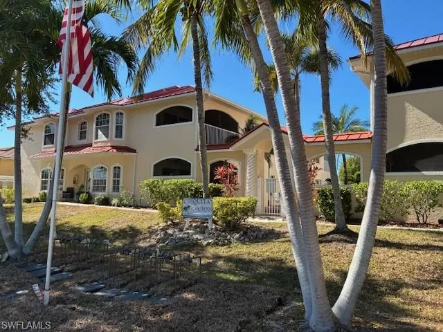 View of front of house with a metal roof, stucco siding, and a front yard