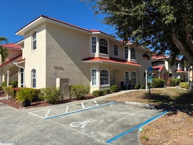 View of building exterior featuring uncovered parking