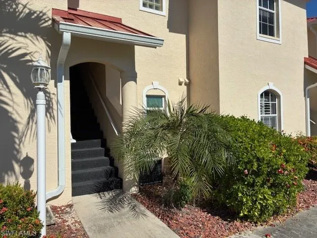View of exterior entry featuring a standing seam roof, stucco siding, and a metal roof