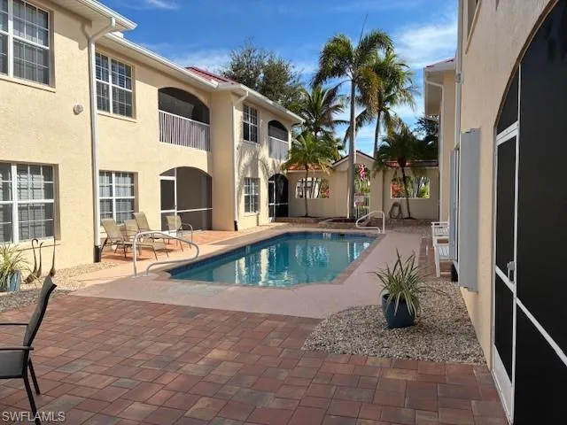 Swimming pool with a patio, a sunroom, and a balcony