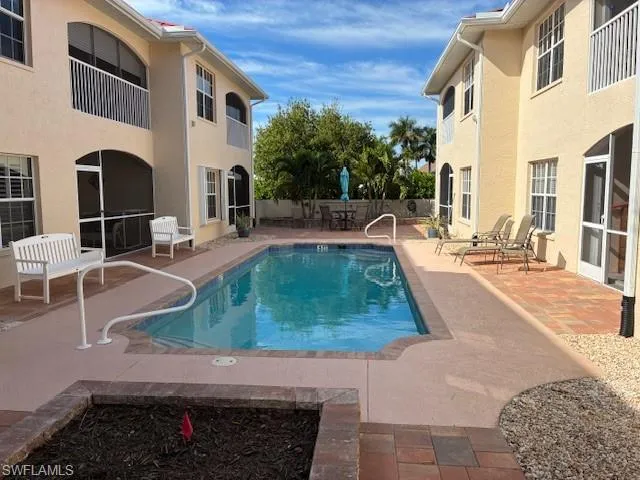 Community pool featuring a patio area, a balcony, and a sunroom