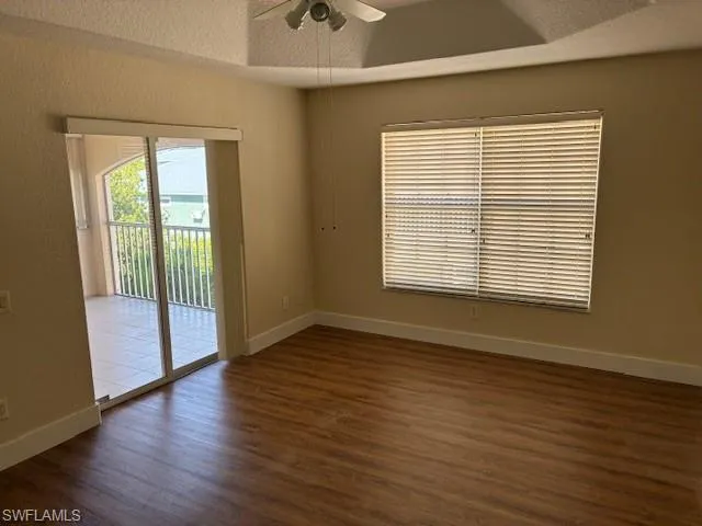 Unfurnished room featuring dark wood-style flooring and a ceiling fan