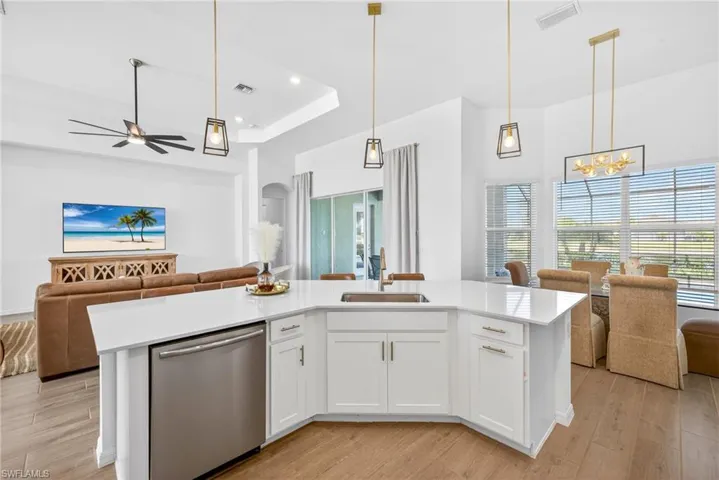 Kitchen with white cabinets, open floor plan, hanging light fixtures, dishwasher, and recessed lighting