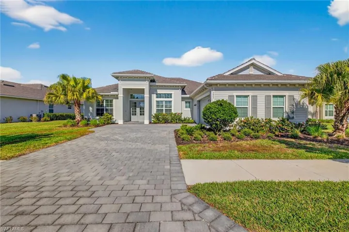 View of front of home featuring decorative driveway, a garage, a front lawn, and french doors
