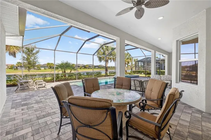 View of patio featuring a sunroom, outdoor dining area, an outdoor pool, glass enclosure, and ceiling fan
