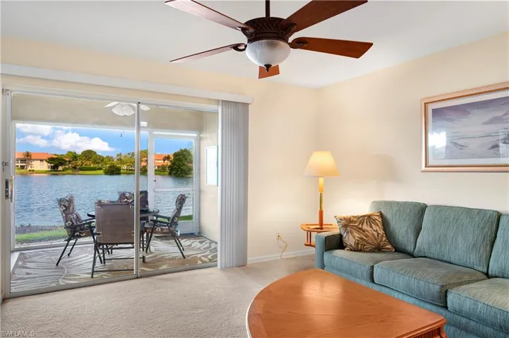 Sunroom with a textured wall, a textured ceiling, and a water view