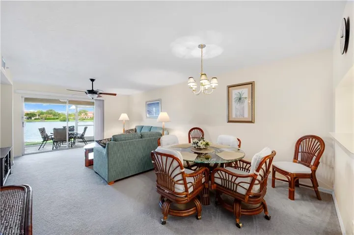 Dining area featuring a chandelier, ceiling fan, and carpet floors